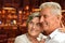 Happy old couple posing on blurred casino hall background