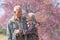 Happy old couple smiling in a park.mature couple with cherry blossom sakura tree.seniors lover family and healthcare concept
