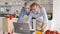 Happy old couple using laptop together ordering food delivery in grocery shop.