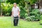 Happy old elderly Asian man uses a walker and walks in the backyard. Concept of happy retirement With care from a caregiver and