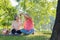 Happy old elderly couple spouses relaxing and sitting on a blanket in the park and sharing few precious memories. Senior couple