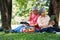 Happy old elderly couple spouses relaxing and sitting on a blanket in the park and sharing few precious memories. Senior couple