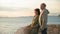 happy old female and male pensioners enjoying their vacation at sea and admiring sunsets while standing on the