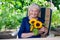 Happy Old Lady Sitting on Chair Holding Sunflowers