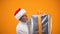 Happy old man in santa hat carrying huge giftbox, holiday sale, big discounts