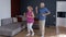 Happy old senior couple dancing having fun celebrating retirement anniversary in living room at home