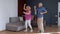 Happy old senior couple dancing having fun celebrating retirement anniversary in living room at home