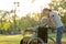 Happy old senior woman in wheelchair with granddaughter walking outdoor at park,smiling child girl and elderly grandmother rest