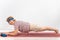 A happy old woman doing a plank on a sports mat. Elderly lady doing fitness exercises on white background.