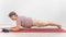 A happy old woman doing a plank on a sports mat. Elderly lady doing fitness exercises on white background.
