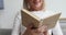 Happy old woman relaxing holding reading book, close up view