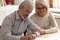 Happy older family couple husband and wife sign legal paper