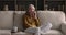 Happy older lady grandmother relax on sofa talk on phone