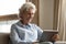 Happy older woman holding digital tablet, reading electronic book.