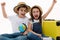 Happy overjoyed kids travelers experiencing happiness while going for summer vacations, sitting with globe and suitcase