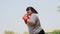 Happy overweight Asian woman wears Red boxing gloves Try to lose weight by exercise in the garden by punching. Concept of Health