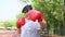 Happy overweight Asian woman wears Red boxing gloves Try to lose weight by exercise in the garden by punching. Concept of Health