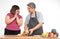 Happy overweight couple cooking a burger in the kitchen room. A vegetable on the table. Concept of happy family and binge eating