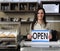 Happy owner of a cafe showing open sign