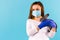 Happy Pandemic 2021 Easter. Young caucasian woman wearing medical blue gloves and mask holding a rabbit on shoulder