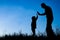 Happy parent with child in the park outdoors silhouette