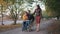 Happy parenthood, the child sits on the lap of his disabled father in a wheelchair while walking with his mother on