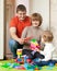 Happy parents and child plays with meccano