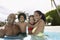 Happy Parents With Children In Swimming Pool