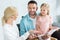 happy parents with cute little daughter reading book together