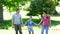 Happy parents and daughter jumping in the park