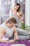 Happy parents. Father laying down on the floor and playing on tablet. Mother breast feed her baby boy.