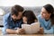 Happy parents with little daughter having fun bonding reading to