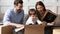 Happy parents with little son unpacking belongings on moving day