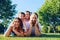 Happy parents lying on grass with their children