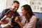 Happy parents playing with baby girl on dadï¿½s knee, close-up