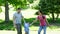 Happy parents swinging their son between them in the park