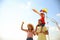 Happy parents and their child playing with kites on sunny day. Spending time in nature