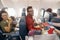 Happy passengers smiling while female flight attendant serving lunch on board