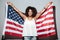 Happy patriotic african woman holding US flag