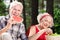 Happy pensioner eating watermelon and his wife enjoying grapes