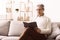 Happy pensioner reading book, having rest on sofa