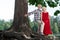 Happy pensioner touching the tree while hugging his aged wife