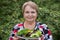 Happy pensioner woman with vegetables at dacha