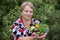 Happy pensioner woman with vegetables at dacha