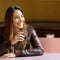 Happy pensive woman refreshing with a drink in a restaurant