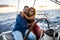Happy people caucasian adult couple enjoy the sail boat trip on summer holiday vacation - outdoor leisure activity with ocean and