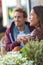 Happy people eating brunch at cafe. Young couple hipsters drinking coffee at restaurant table outside sidewalk terrace at parisian