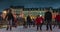 Happy people gliding by night on the ice rink