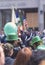 Happy people with green bowler hats and balloons cheering at St. Patrickâ€™s Day parade in the streets