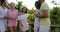 Happy People Group Talking Outdoors On Terrace Looking At Beautiful Landscape With Sunset Over Tropical Forest, Friends